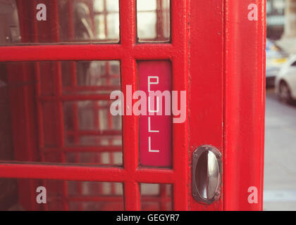 Detail des "Pull" Schild an traditionellen rotes Telefon Box Tür. Stockfoto