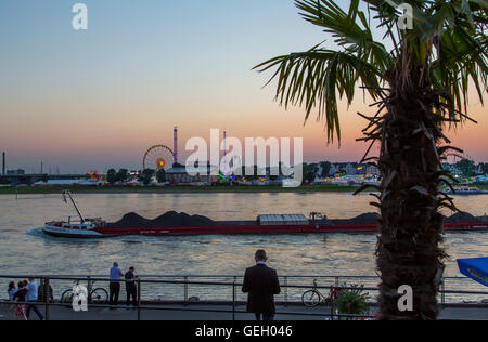 Sonnenuntergang am Rhein, Düsseldorf, Deutschland, Jahrmarkt auf der gegenüberliegenden Seite des Flusses, Fracht Boot, Sommernacht, Stockfoto