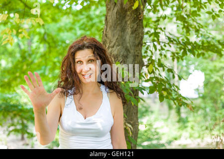 Faszinierend, Reife Frau zeigt Nummer fünf in einem grünen Garten Stockfoto