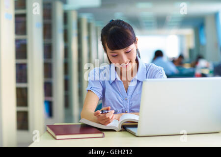 eine hübsche junge asiatische oder chinesischen College Student Studium in der Bibliothek Stockfoto