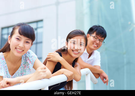 drei glückliche junge chinesische oder asiatische Studenten Blick auf Kamera Lächeln Stockfoto