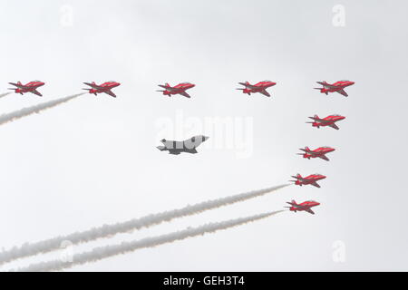 Flypast einer Lockheed Martin F35 durch die roten Pfeile auf der Farnborough International Airshow 2016, UK begleitet Stockfoto