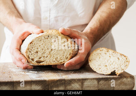 Baker, die holding ein frisch gebackenes Brot. Stockfoto