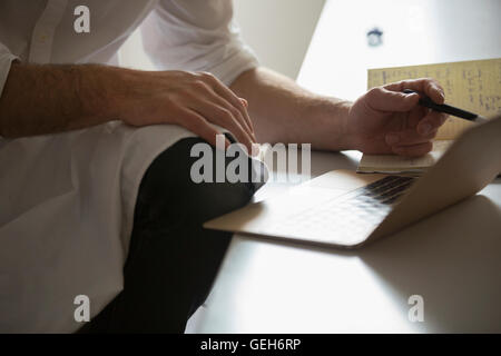 Nahaufnahme eines Mannes auf einem Laptop arbeiten. Stockfoto