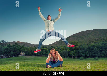 Mann hohe Sprünge über eine Frau, während sie in Angst schreit Stockfoto