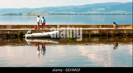 Golubac, Serbien - 5. Juni 2016: Zwei Männer warten auf das dritte man zu binden, das motor-Schlauchboot auf dem Fluss Danube Pier, Stockfoto