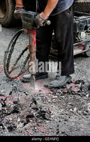 Belgrad, Serbien - 21. Juni 2016: Arbeiter jackhammering Straße. Abgeschossen von der Taille. Stockfoto