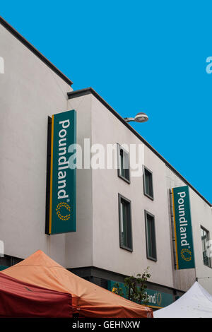 SAINT AUSTELL, CORNWALL, UK - 9. Juli 2016: Poundland speichern Zeichen auf weiße Wand mit blauem Himmel. Saint Austell Ladengeschäft. Stockfoto