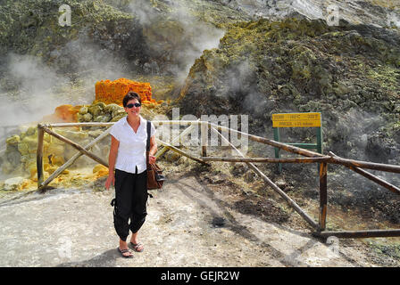 Campi Flegrei, Kampanien, Italien. Solfatara Vulkan. Eine touristische Frau posiert in der Nähe der Gran Fumarole. Stockfoto