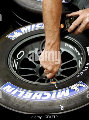 Datei - Datei Bild vom 30. Juni 2005 einen Mechaniker aus der Forumla 1 zeigt racing team BAR-Honda Kontrolle des Drucks in einem Michelin-Reifen während des Trainings vor einer Grand Prix Racein Magny-Cours, Frankreich. Foto: Kerim Otken Stockfoto