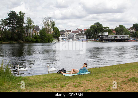 London, UK. 26. Juli 2016. Eine Frau liegt am Ufer der Themse in Hampton Court an einem bewölkten Tag Credit: Amer Ghazzal/Alamy Live-Nachrichten Stockfoto