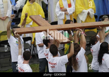 Krakau, Polen. 26. Juli 2016. Junge Pilger tragen das Kreuz für den Hauptaltar in Richtung Altar. Zehntausende von jungen Pilger kamen zur Eröffnung Masse der World Youth Day 2016 in den Blonia Park in Krakau. Die Messe wurde von Kardinal Stanislaw Dziwisz, Erzbischof von Krakau gefeiert. Bildnachweis: Michael Debets/Alamy Live-Nachrichten Stockfoto