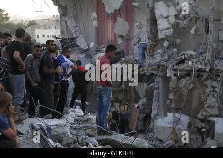 (160727)--HEBRON, 27. Juli 2016 (Xinhua)--Palästinenser untersuchen ein Haus, das während eines israelischen Überfall im Dorf Surif, nördlich von Hebron im Westjordanland, am 27. Juli 2016 schwer beschädigt wurde. Israelische Sicherheitskräfte einen palästinensischen Mann getötet und drei andere, die angeblich einen tödlichen Angriff gegen Israelis Anfang dieses Monats durchgeführt festgenommen, sagte die israelische Armee am Mittwoch. (Xinhua/Mamoun Wazwaz) (Nxl) Stockfoto