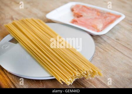 Vorbereitung Vollkorn Spaghetti mit Räucherlachs und Tomatensauce Stockfoto