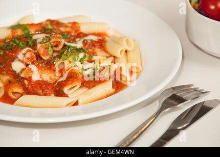 Nahaufnahme von frisch zubereiteten Pasta Penne Arabiata mit grüner Petersilie garniert Stockfoto