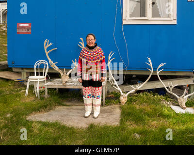 Mädchen junge Inuit in Grönland Tracht draußen blau bemalten Haus Itilleq West Grönland mit Rentier horn Dekoration Stockfoto