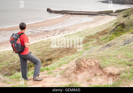 Männliche Wanderer auf Cleveland Weise Küstenweg mit Blick auf Cattersty Sand-Strand in Skinningrove, North Yorkshire, England. UK Stockfoto