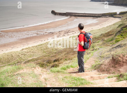 Männliche Wanderer auf Cleveland Weise Küstenweg mit Blick auf Cattersty Sand-Strand in Skinningrove, North Yorkshire, England. UK Stockfoto