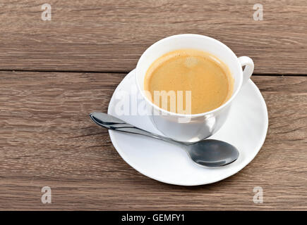 Eine Tasse Kaffee in einer weißen Tasse auf hölzernen Hintergrund Stockfoto
