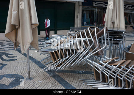 Ein Café Arbeiter fegt Wurf vom Gehsteig am Morgen nach Portugals Sieg über Frankreich in die Euro 2016-Turnier Finale Stockfoto