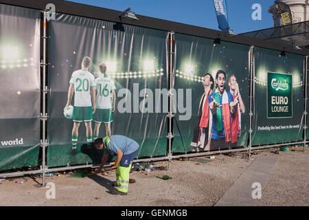 Ein Stadt Arbeiter fegt Wurf unter Carlsberg Werbung in Lissabons Praca Commercio am Morgen nach der portugiesischen Sieg Stockfoto