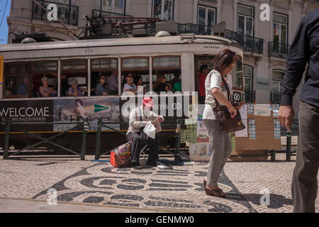 Eine traditionelle Lissaboner Tram übergibt Fußgänger in Baixa u-Bahn-Station in der Nähe der Praça Luis de Camoes, im Stadtteil Chiado Stockfoto