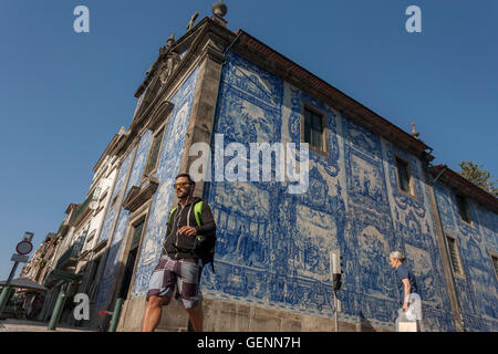 Fußgänger weitergeben unter traditionellen Azulejo-Fliesen an der Wand der Capela Das Almas (Kirche), Rua Santa Catarina, Porto Stockfoto