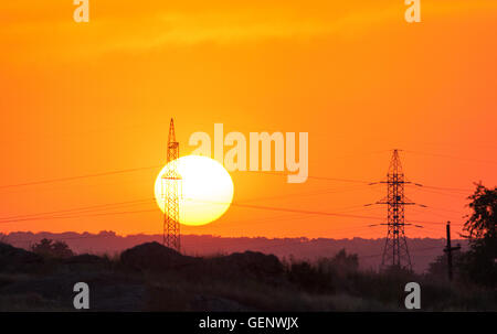Hochspannungs-Post bei Sonnenuntergang. Hochspannungs-Turm auf dem Hintergrund der bunten Himmel Stockfoto