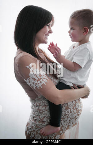 Eine schwangere Frau mit ihrem kleinen Sohn in die Arme. Stockfoto