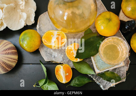 Draufsicht auf eine Tabelle mit in Scheiben geschnittenen Orangen und Gläser. Stockfoto
