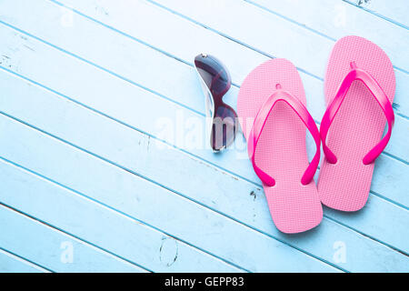 Rosa Flip Flops und Sonnenbrillen auf blue Floor. Stockfoto