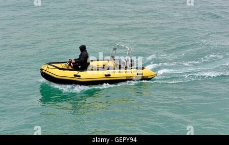 Ein Mann mit Kapuzenjacke fahren ein St Ives fahren selbst mieten Boot Cornwall England UK Stockfoto