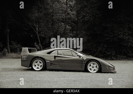 Schwarz / weiß seitlich Schuss von einem Ferrari F40 geparkt auf dem Rasen mit Bäumen hinter Stockfoto