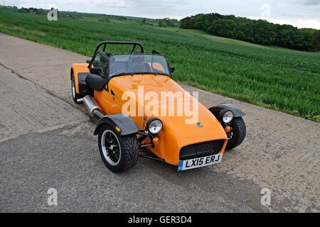 Ein oranger Caterham-Sportwagen auf der alten Landebahn Stockfoto