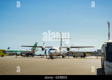 HERAKLION, Griechenland - 28. April 2016: Flugvorbereitung. Mechaniker dient zwei Motor-Propeller Zivilflugzeug in Heraklion Stockfoto