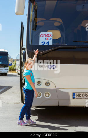 HERAKLION, Griechenland - 28. April 2016: Mädchen posiert in der Nähe von modernen weißer Touristenbus mit Firmenlogo Anex Tour, geparkt transport Stockfoto