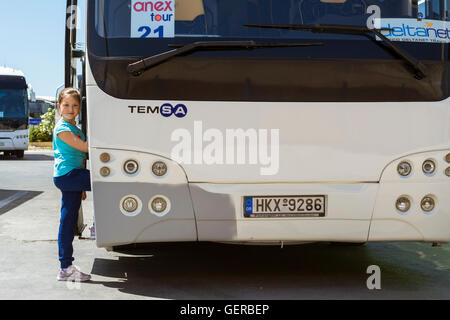 HERAKLION, Griechenland - 28. April 2016: Mädchen posiert in der Nähe von modernen weißer Touristenbus mit Logo der Anex Reiseunternehmen und DeltaNet Stockfoto