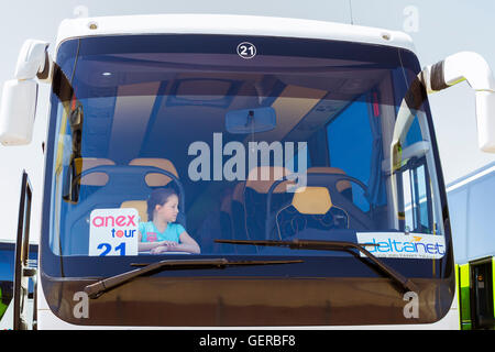 HERAKLION, Griechenland - 28. April 2016: Mädchen posiert in moderner weißer Touristenbus mit Logo der Anex Reiseunternehmen und DeltaNet Stockfoto