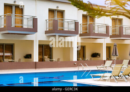 Leere Sonnenliegen und Sonnenschirme sind am Pool leer ohne Touristen in den frühen Morgenstunden. Entspannen Sie und Sonnenbaden Sie, Pool, Crete Stockfoto