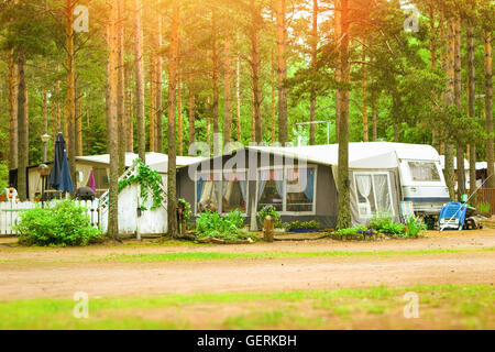 Sommer-outdoor-Aktivitäten, skandinavischen Urlaub. Camping vans und Zelte in einem bewaldeten Campingplatz unter Pinien geparkt. Finnland Stockfoto