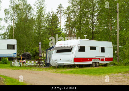 Sommer-outdoor-Aktivitäten, skandinavischen Urlaub im eigenen Haus auf Rädern. Geparkt auf der grünen Wiese im Campingplatz Camping vans und Zelte Stockfoto