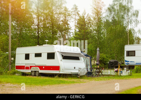 Sommer-outdoor-Aktivitäten, skandinavischen Urlaub im eigenen Haus auf Rädern. Geparkt auf der grünen Wiese im Campingplatz Camping vans und Zelte Stockfoto