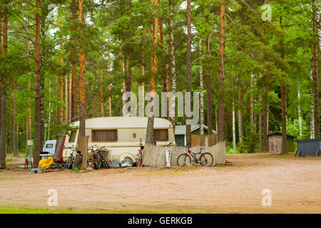 Sommer-outdoor-Aktivitäten, skandinavischen Urlaub. Camping vans und Fahrräder geparkt auf einem bewaldeten Campingplatz unter Pinien. Finnland Stockfoto