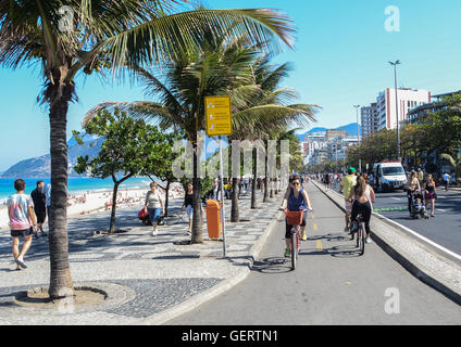 Aktive Bewohner und Touristen schlendern entlang in der Nähe von Posto 9 am Strand von Ipanema, Stockfoto