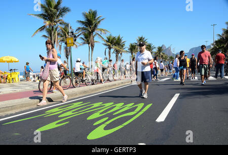 Aktive Einwohner und Touristen schlendern Sie in der Nähe von Posto 9 am Strand von Ipanema, an einem autofreien Sonntag Morgen. Stockfoto