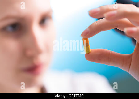 Vitamin-Pille-Kapsel in der Hand der Frau Stockfoto