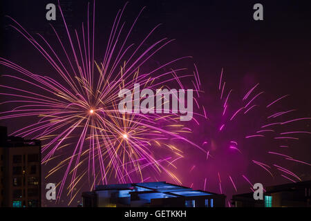 Mehreren Magenta rosa Feuerwerk platzen über Gebäude Stockfoto