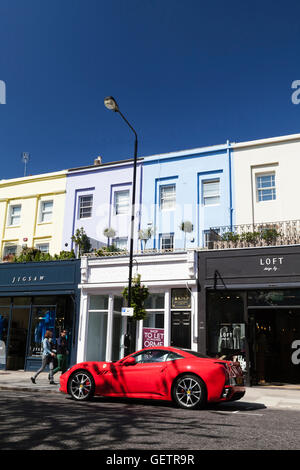 Ein roter Ferrari vor Boutiquen auf Westbourne Grove in Notting Hill geparkt. Stockfoto