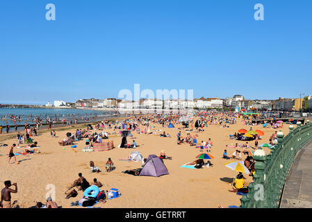 Urlauber genießen die Sonne, Meer und Sand in Margate des berühmten Strand, mit blauem Himmel und klarem blauen Wasser. Stockfoto