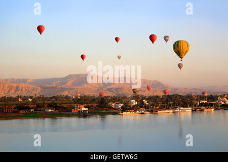 Viele Heißluftballons schweben über den Nil in Luxor bei Sonnenaufgang Stockfoto